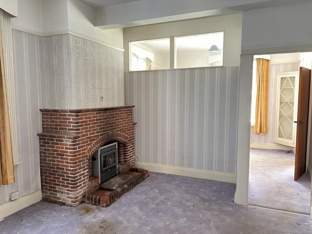 Lot: 129 - FOUR-BEDROOM HOUSE IN NEED OF IMPROVEMENT - Living room with brick fire place